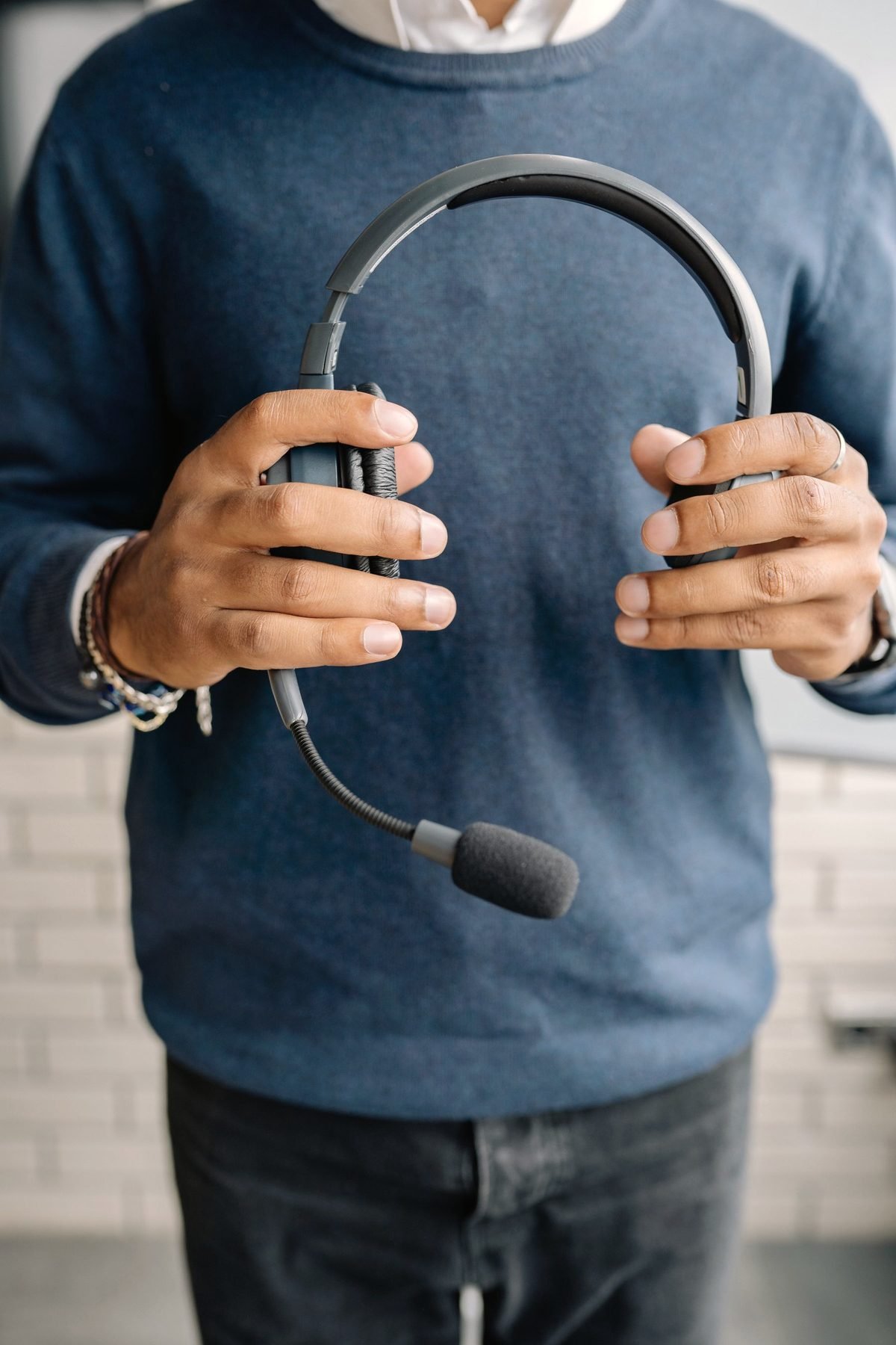 A person holding a telephone headset in both hands